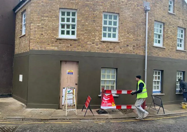 Commercial rendering and maintenance work taking place outside a brick building in Woking Surrey.