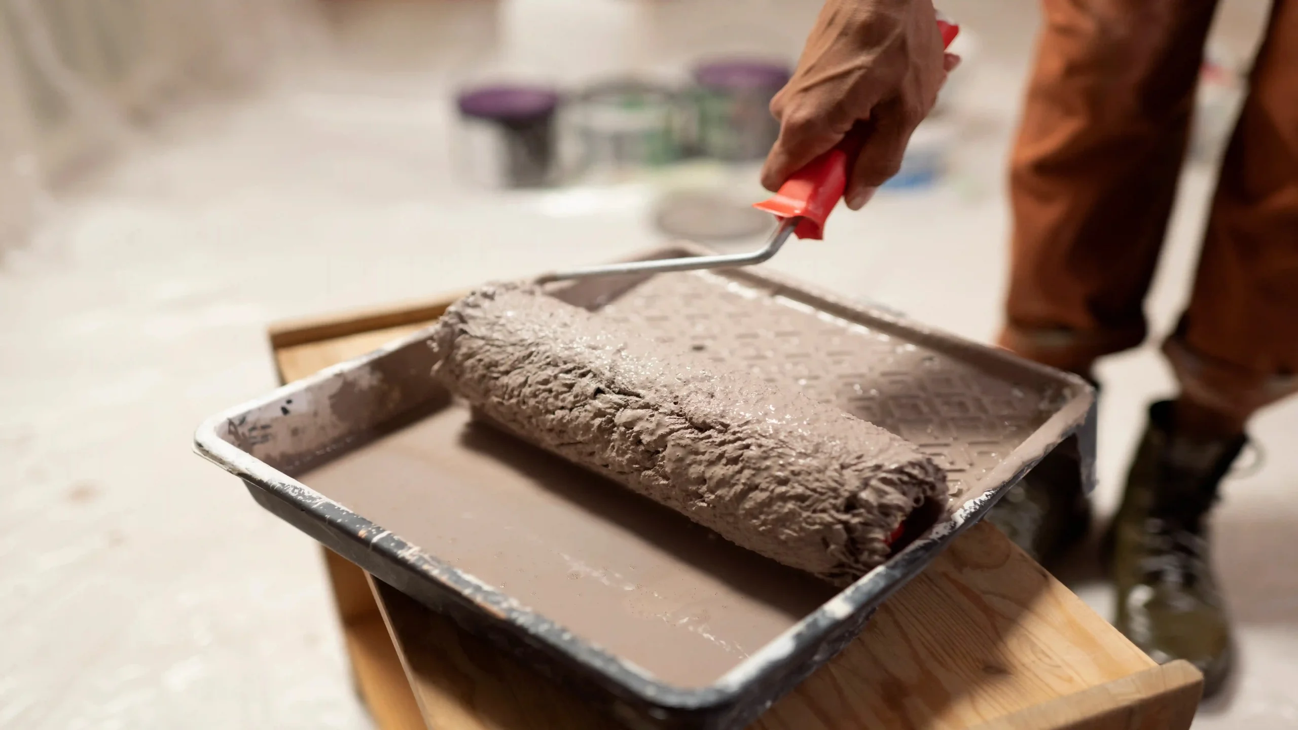 Paint roller being prepared with grey paint during home renovation project in Surrey.