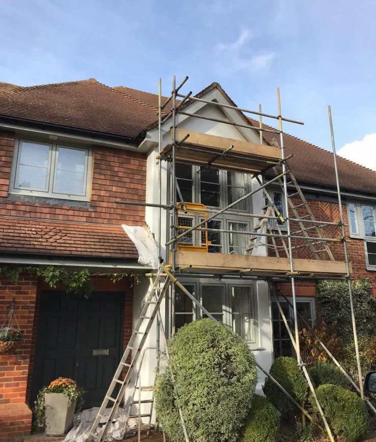 Residential house renovation with scaffolding and rendering work in Leatherhead Surrey.