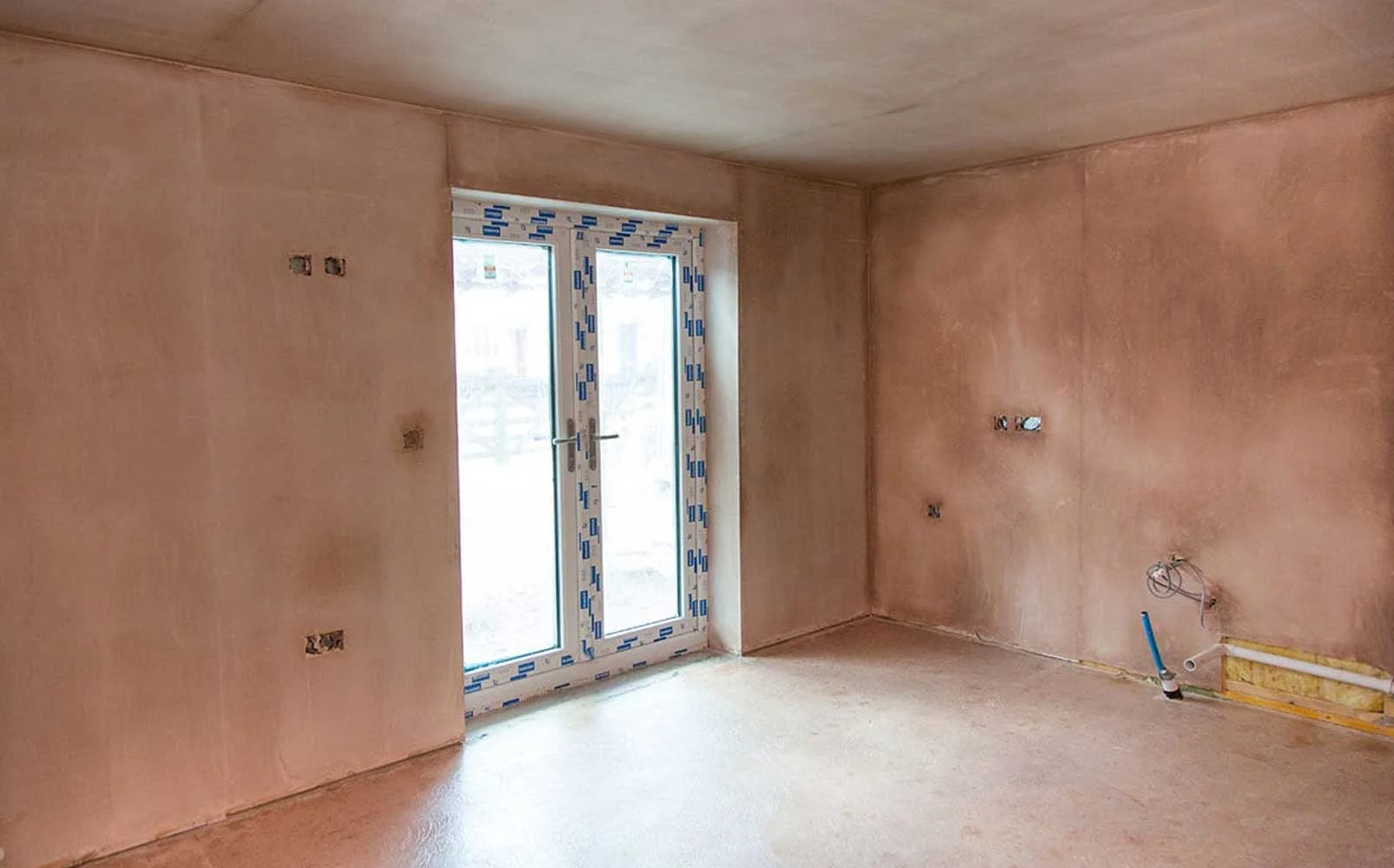 New build interior room with freshly plastered walls and sliding doors in Cobham Surrey.