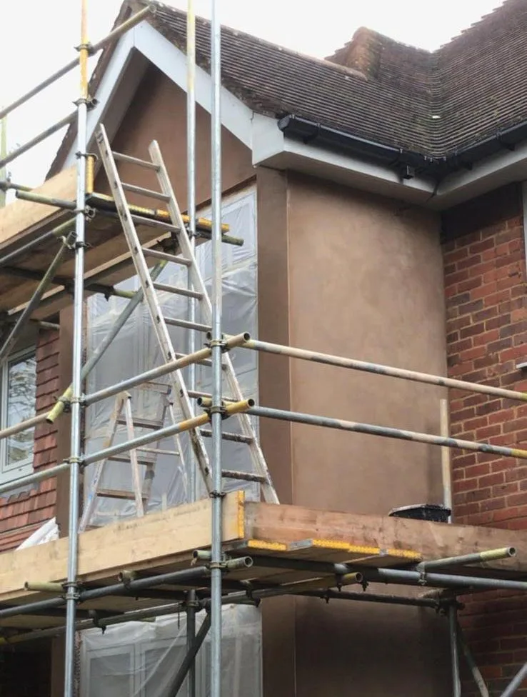Construction site with scaffolding during professional rendering and plastering work in Epsom Surrey.